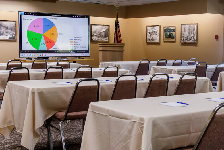 Large room with conference tables and pink chairs