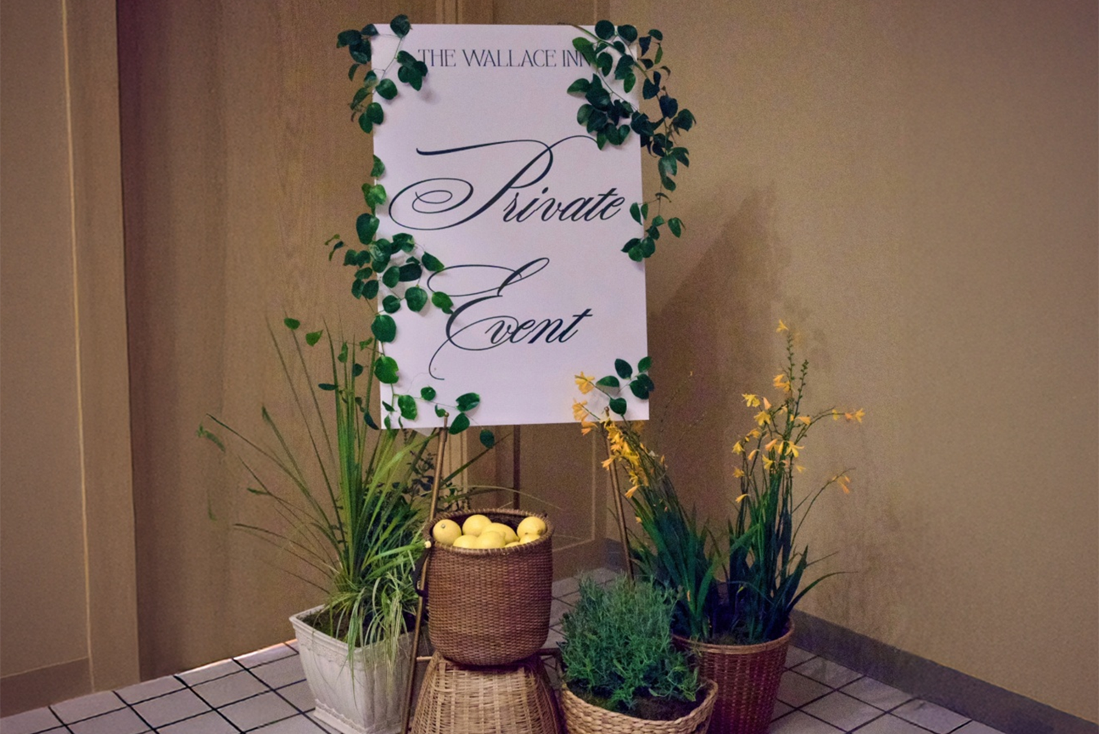 A large white sign that says "Private event" with greenery around it